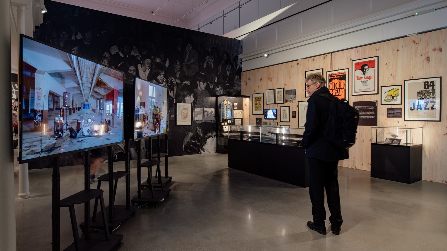 A visitor looking at the 'because the night belongs to us' exhibition