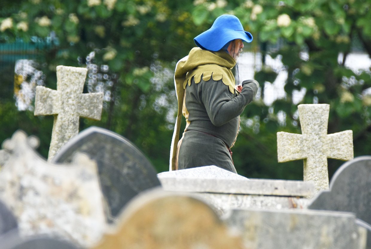 Man in medieval costume in a church yard