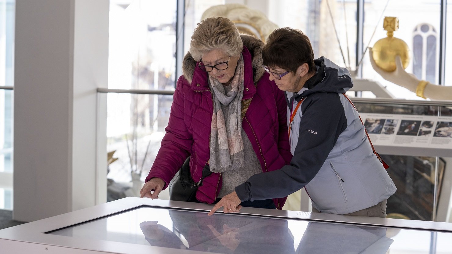 Two women use the map table in The Box Plymouth's Active Archives gallery