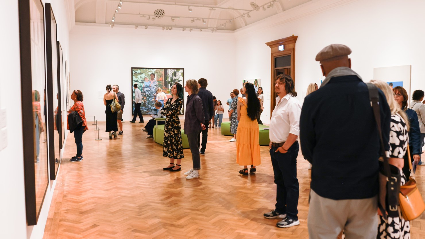 Photograph of people enjoying looking around an exhibition launch