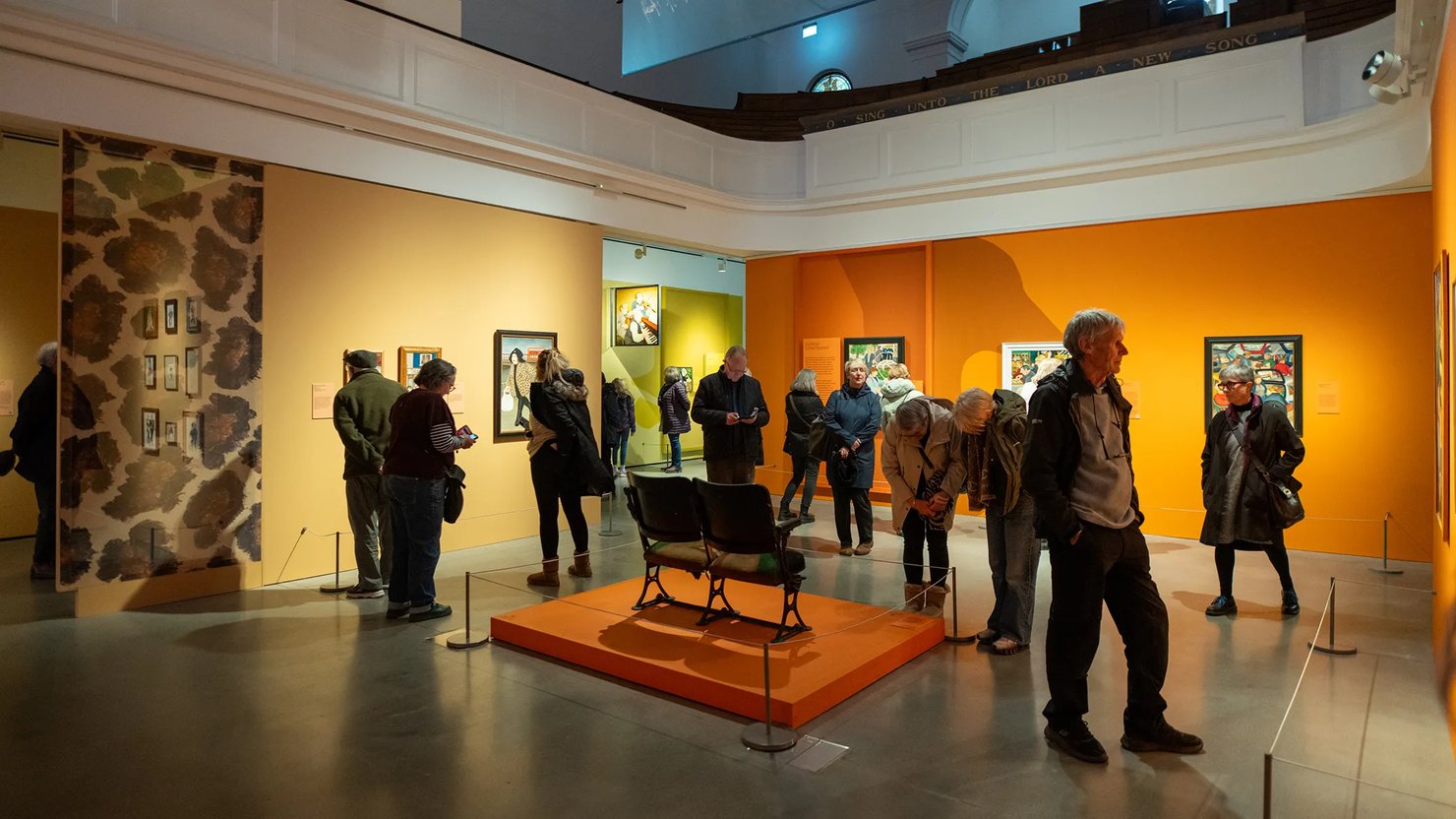 A general shot showing visitors looking around Beryl Cook: Pride and Joy exhibition