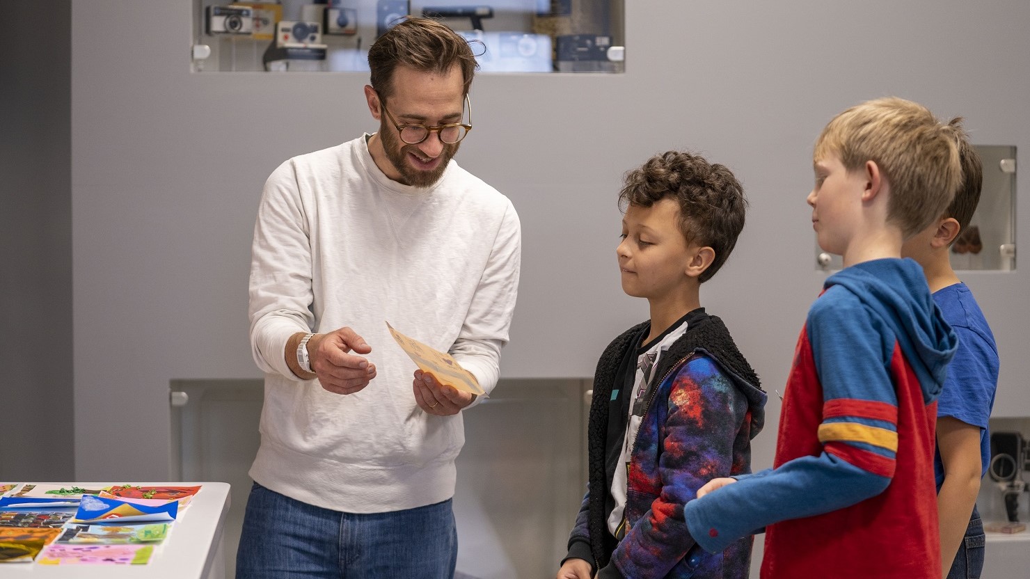 A man helps a group of boys with a craft activity at The Box Plymouth