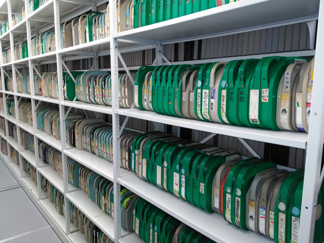 Media tapes in green cases on shelves in an archive store