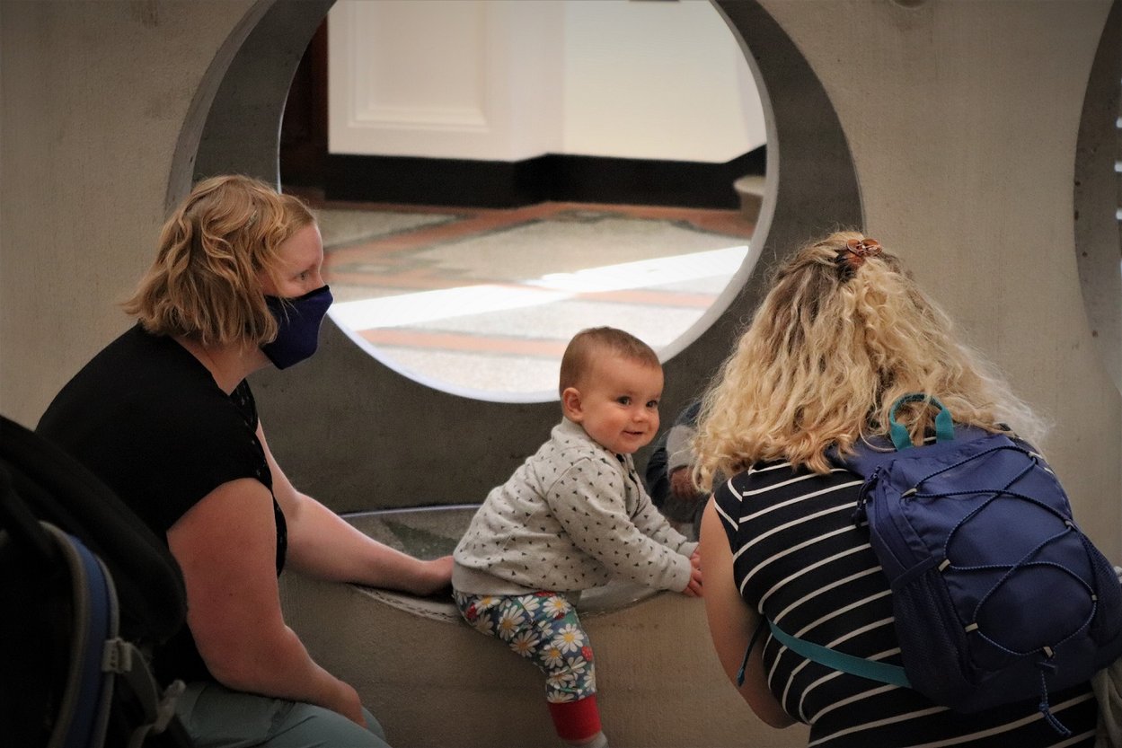 A family with a small baby interact with The Box's 'Figurehead II' sculpture by Alexandre da Cunha