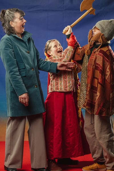 A woman and two children play acting in costumes