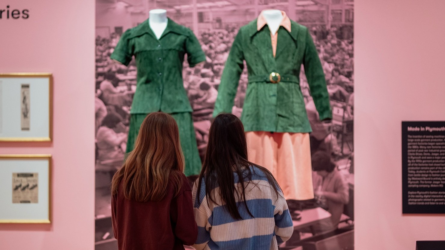 Two female students looking at the 'Dress Code' exhibition at The Box
