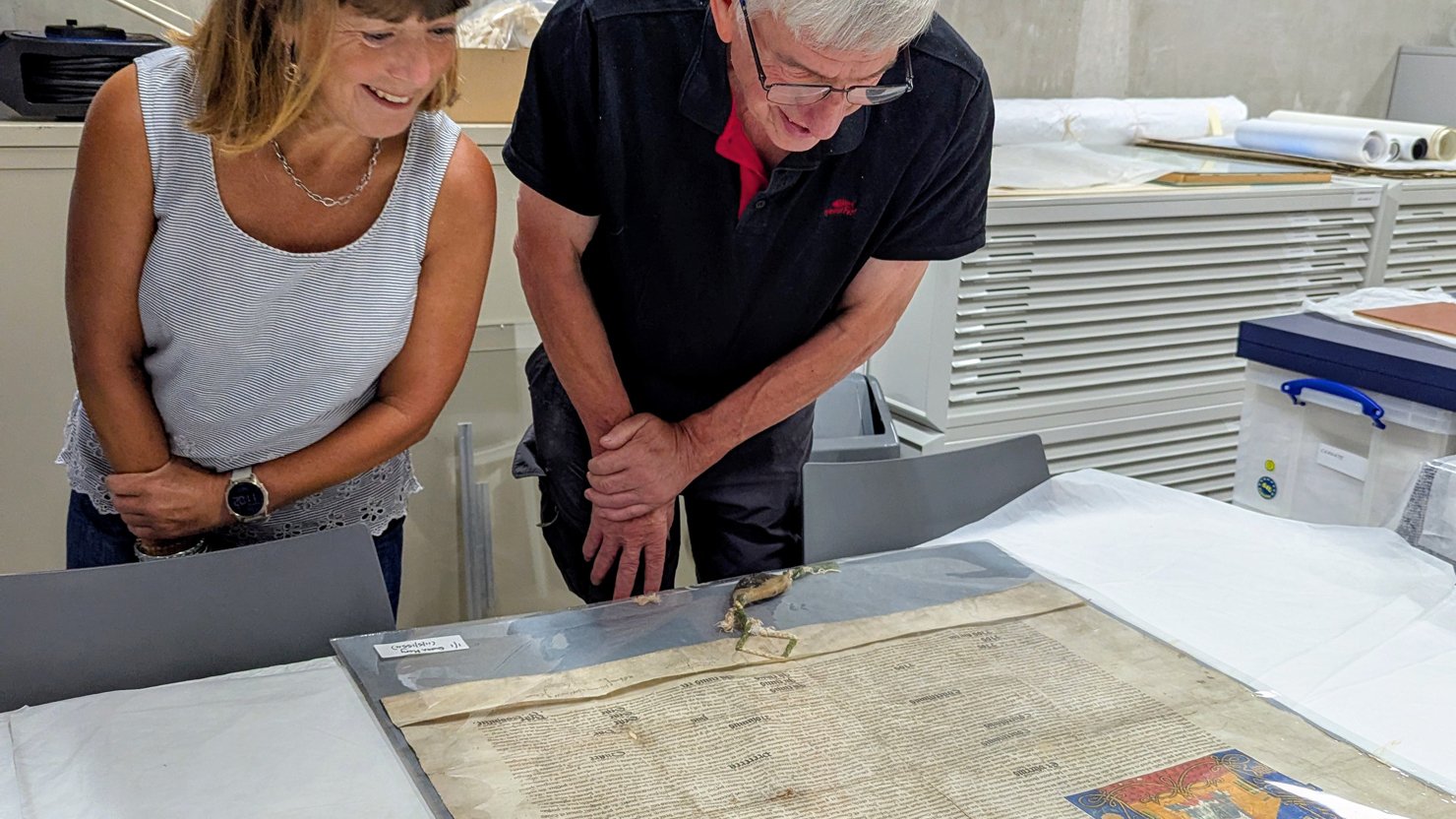 Two adults looking at the Queen Mary Charter in the stores at The Box Plymouth