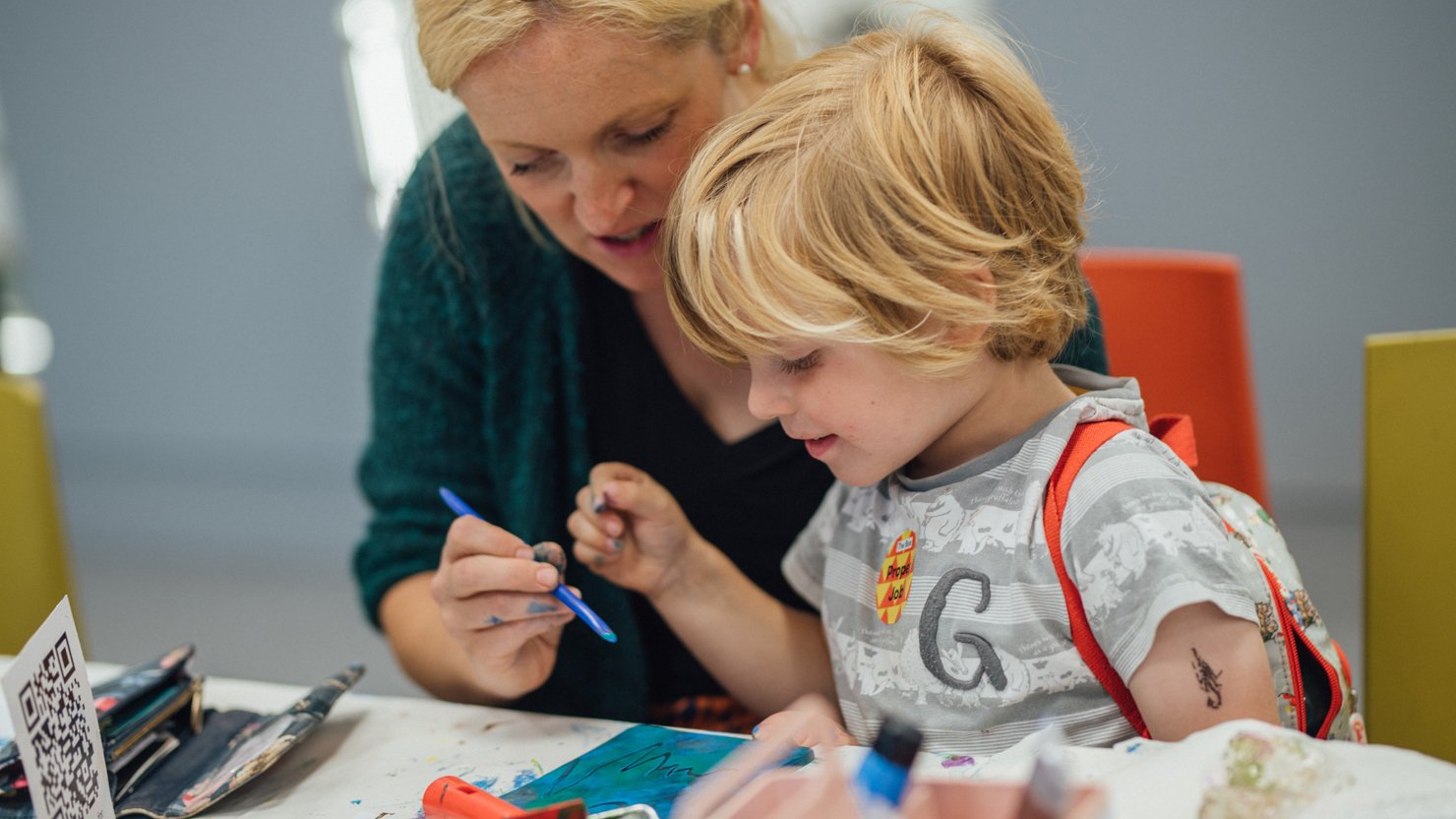 A young boy and adult female take part in a gelli-plate printing activity at The Box Plymouth