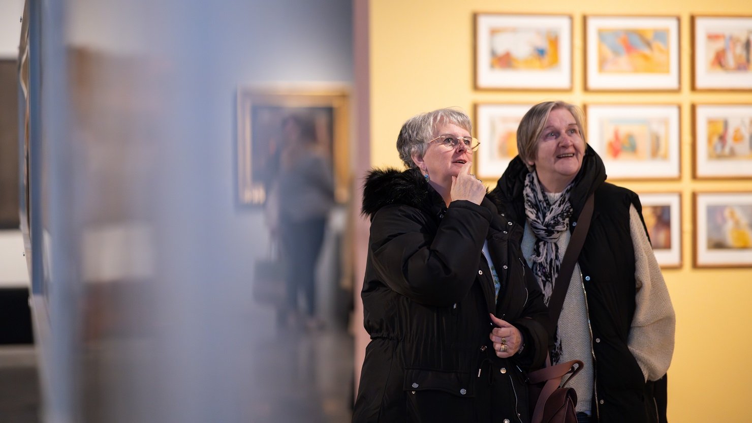 Two women looking at an art exhibition