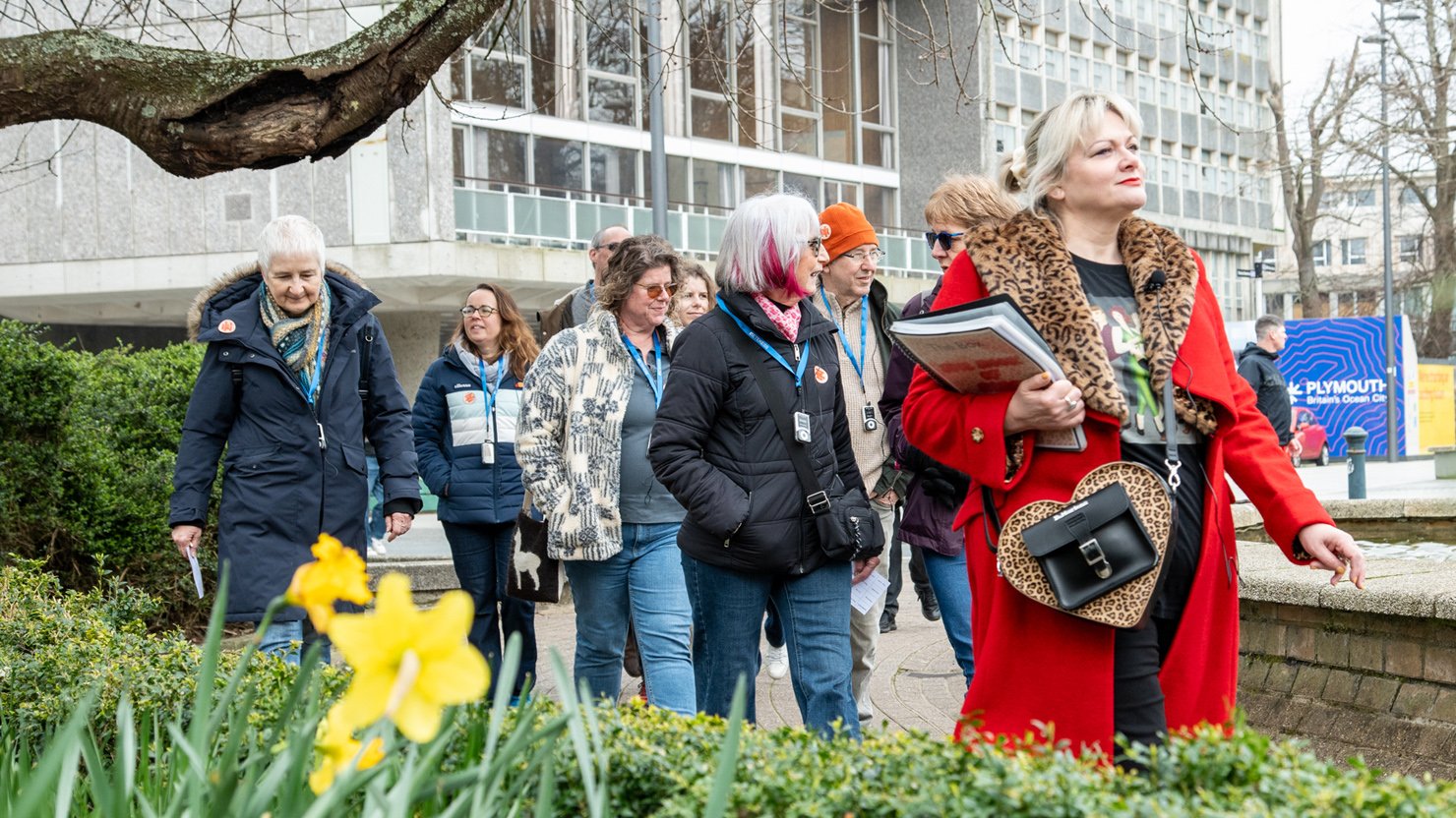Comedian Suzy Bennett leading a group of people on a walking tour