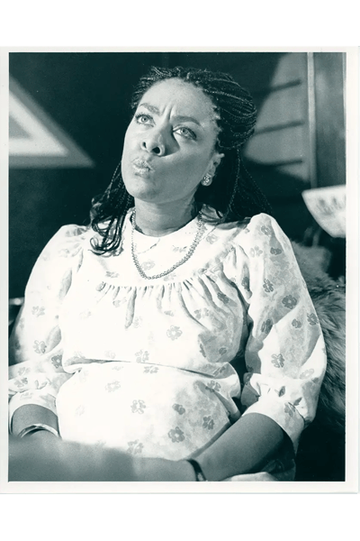 A photograph of a woman sitting, looking like she is thinking.