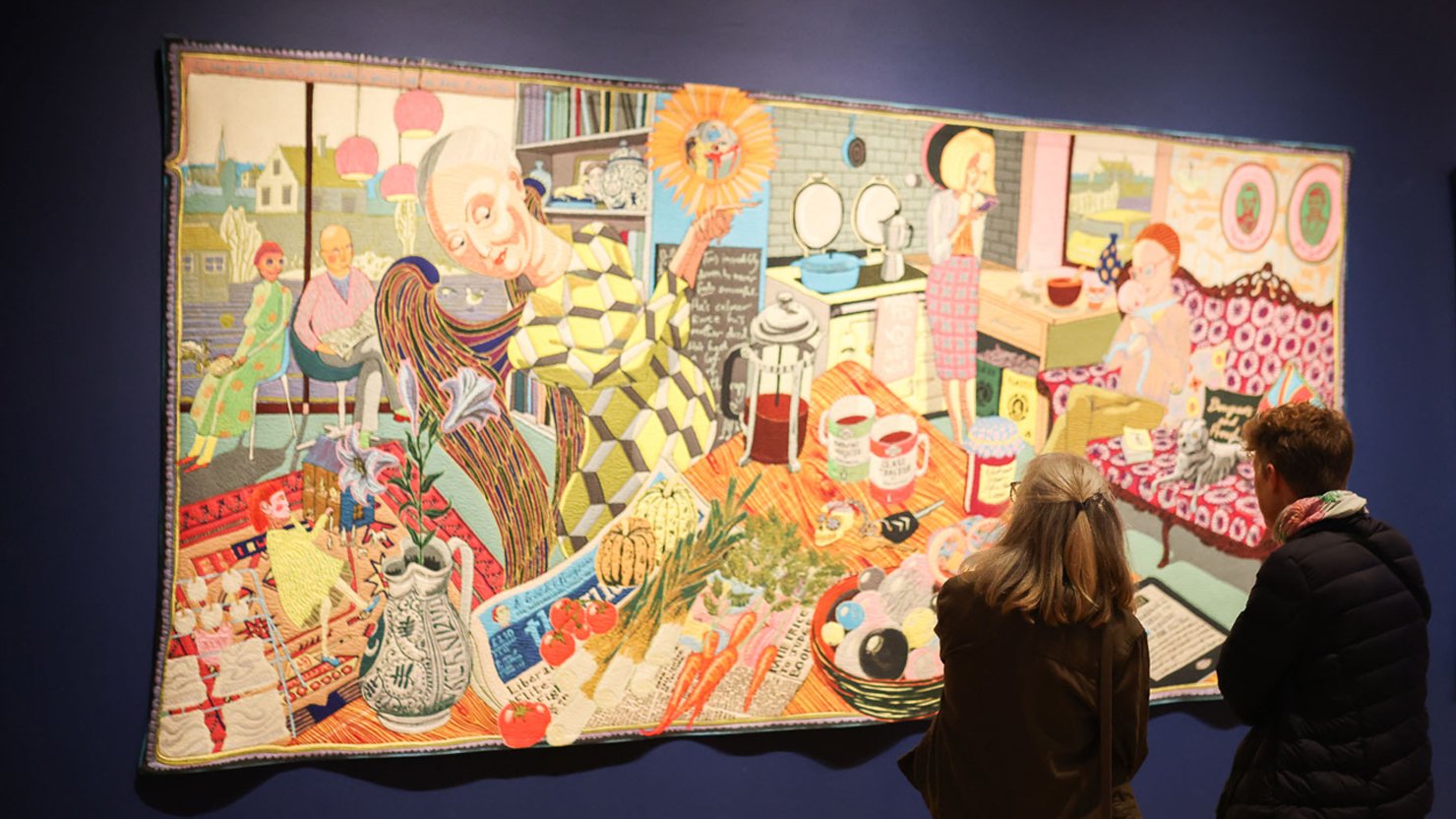 Visitors looking at a Grayson Perry tapestry on display at The Box Plymouth