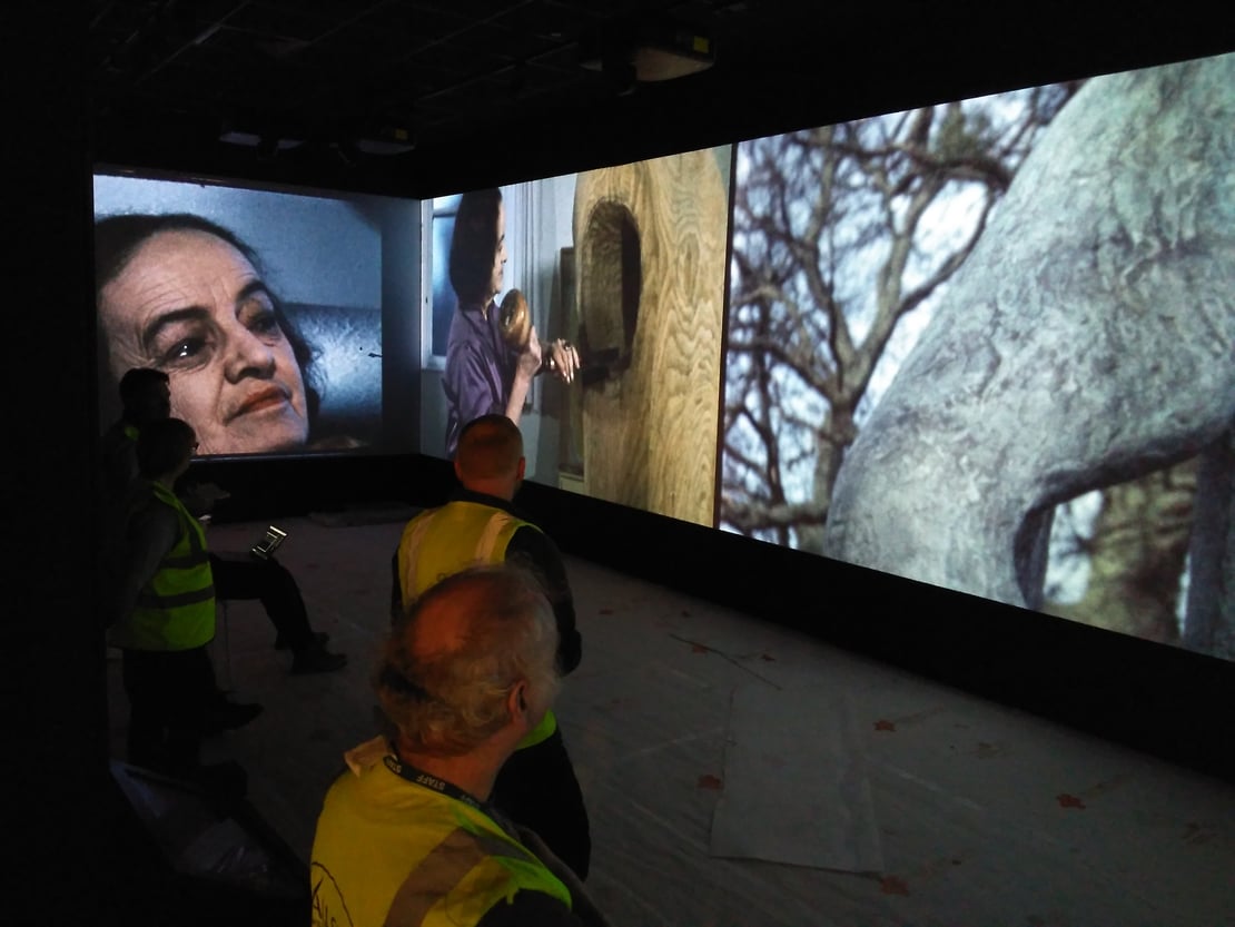 People standing in front of a large screen projection