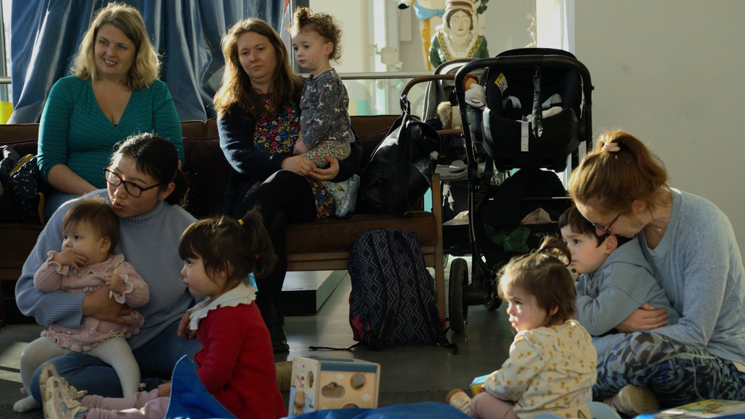 Adults and children sat on the floor listening to a story