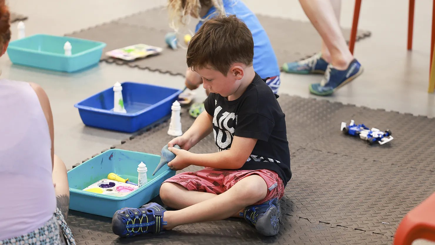 Photograph of a boy using paints in an art workshop