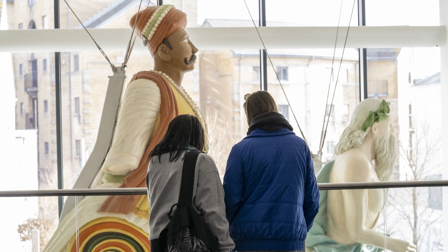 A male and female look at a ship's figurehead in The Box Plymouth's Active Archives gallery