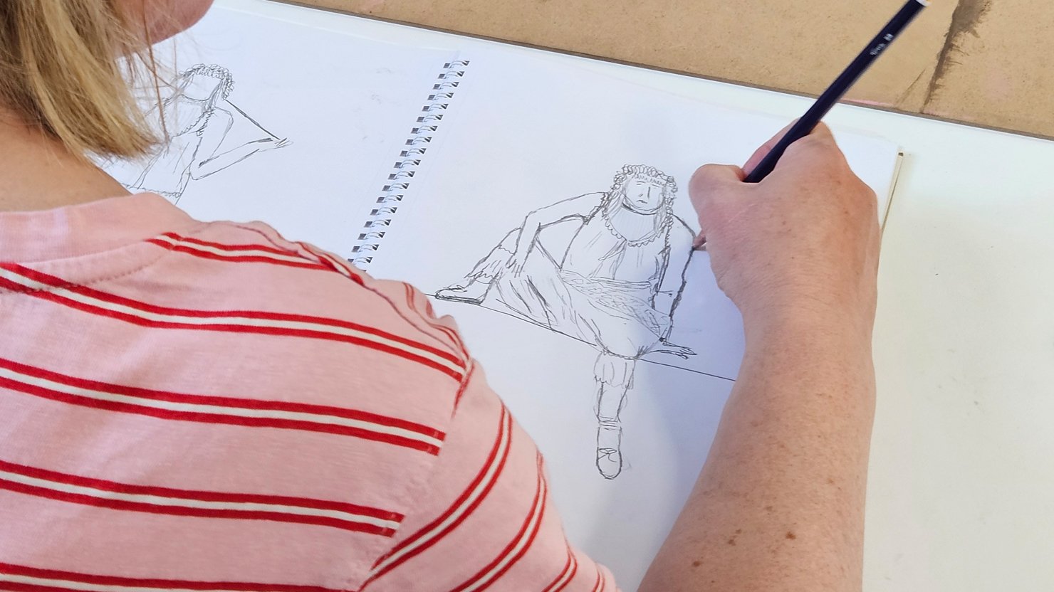A woman draws during a life drawing workshop
