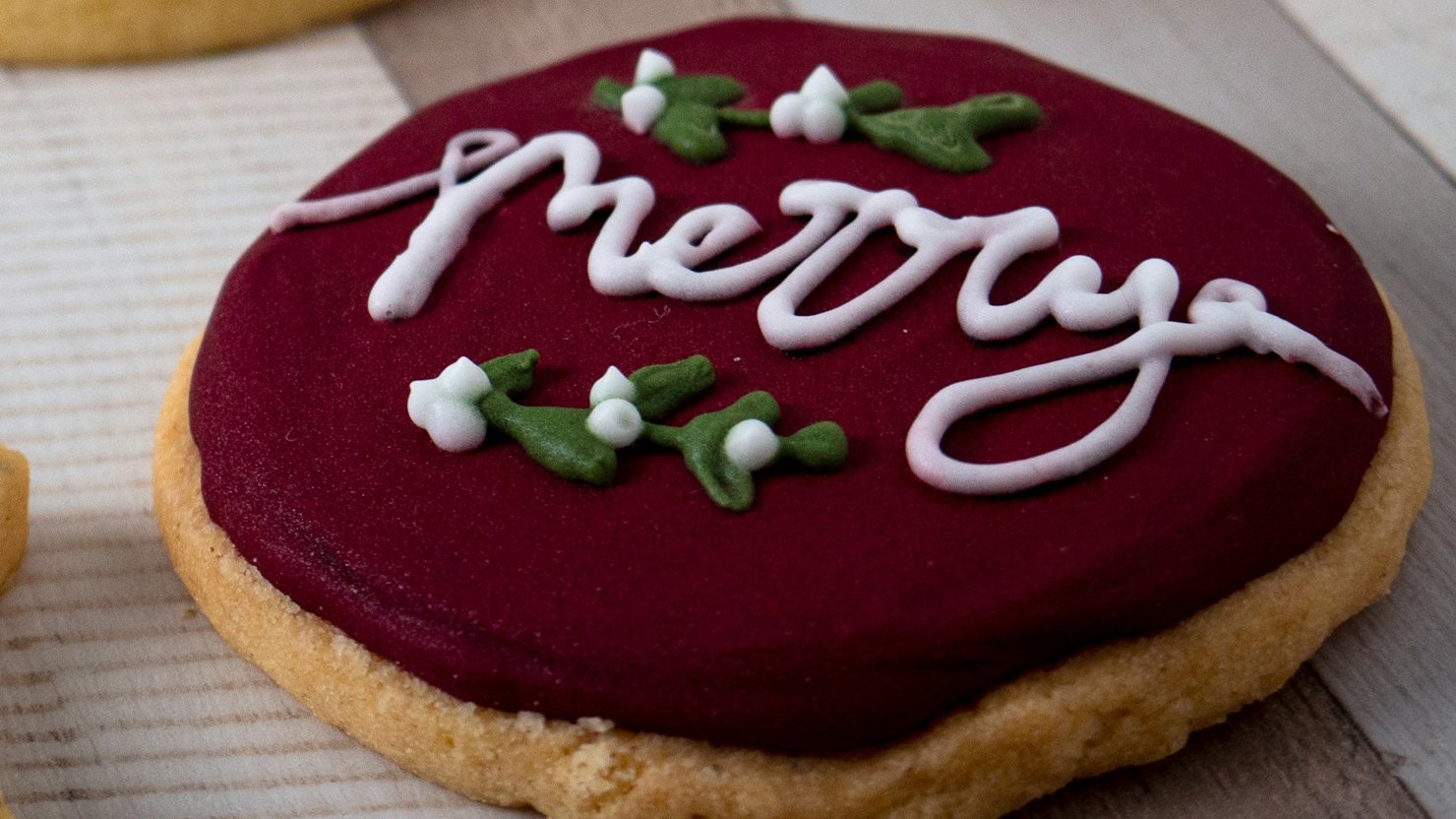A biscuit decorated with a Christmas message and colours