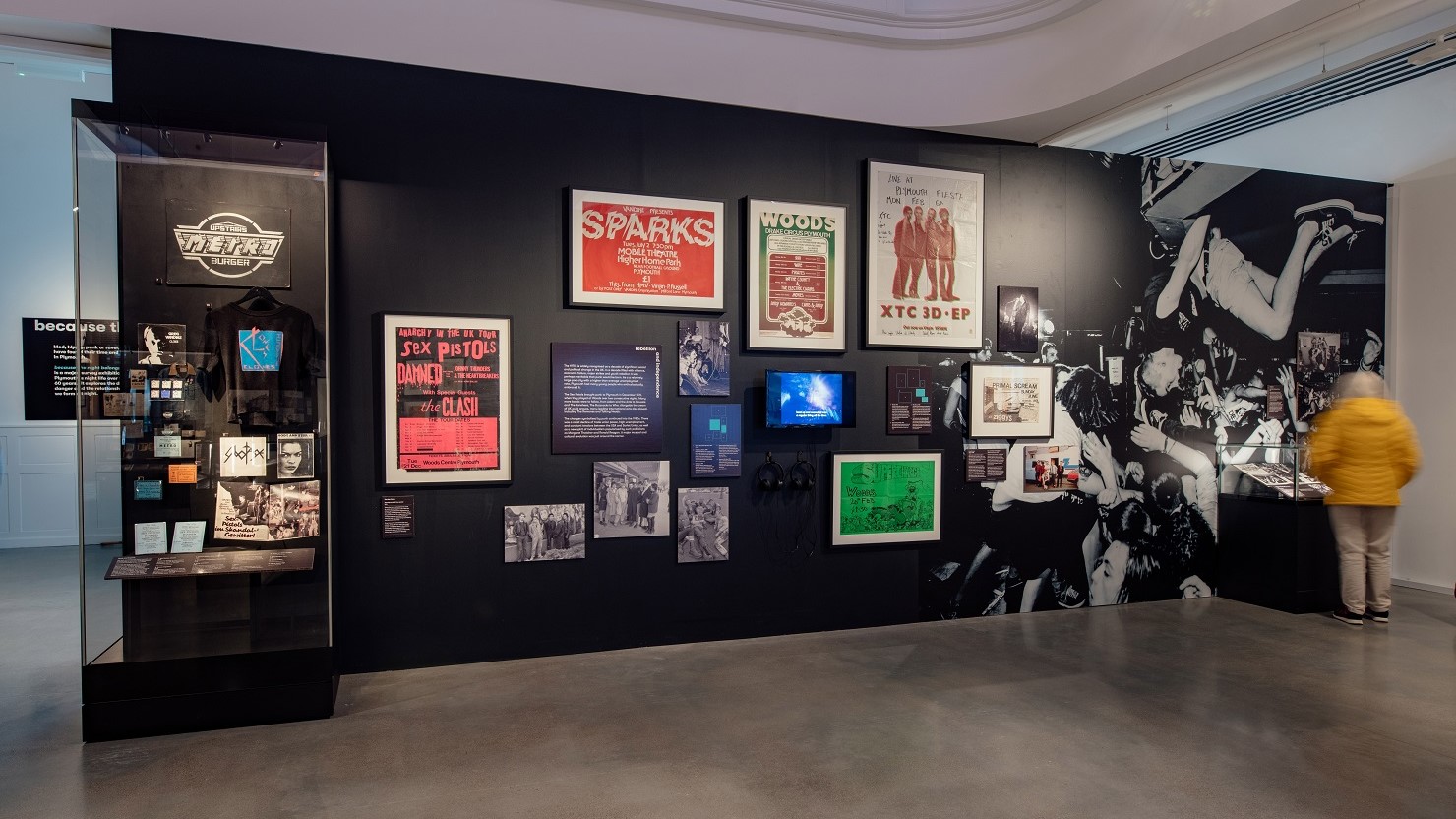 A visitor looking at the 'because the night belongs to us' exhibition