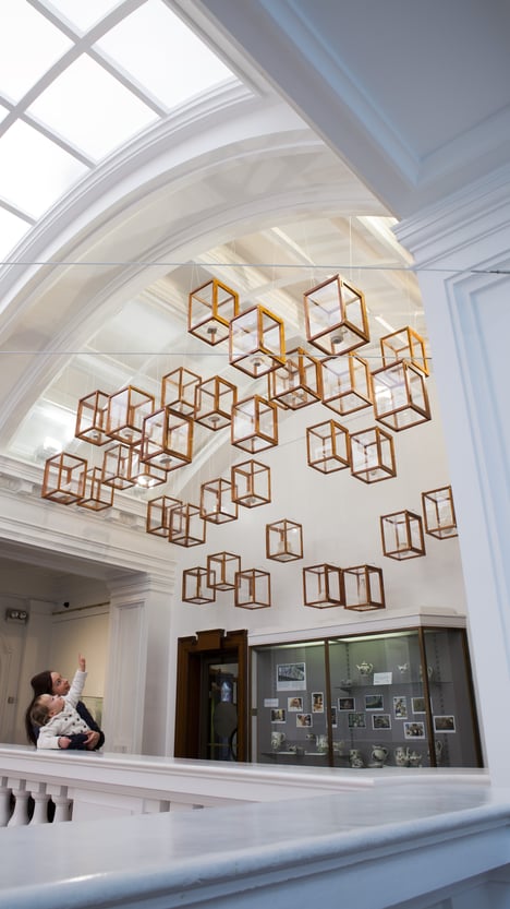 A mum and child looking at 'Plymouth Porcelain: A New Collection' by Clare Twomey in Plymouth City Museum and Art Gallery