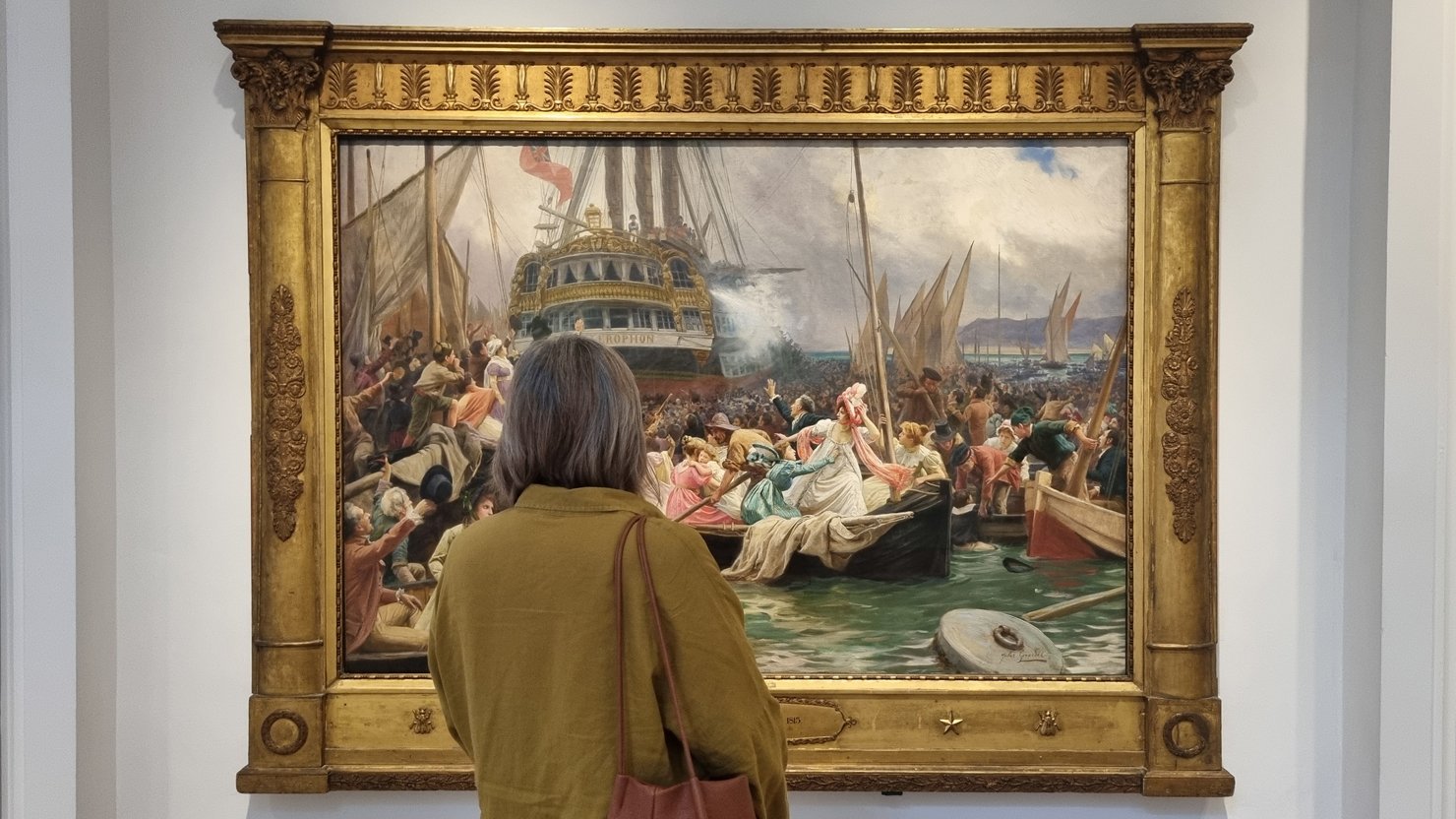 A female visitor looks at the 'Napoleon on the Bellerophon' painting at The Box Plymouth