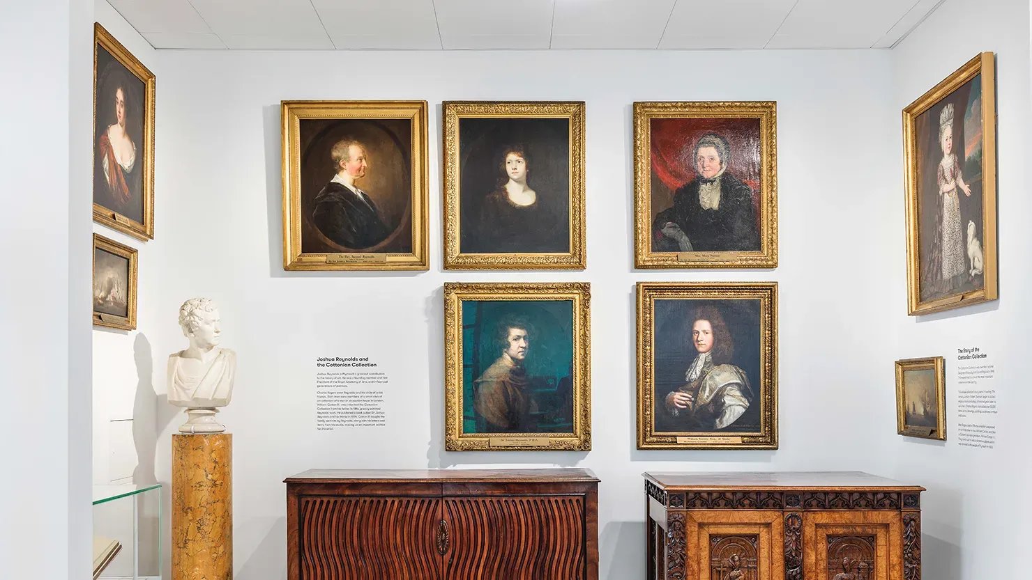 Photograph showing paintings and furniture in a gallery display