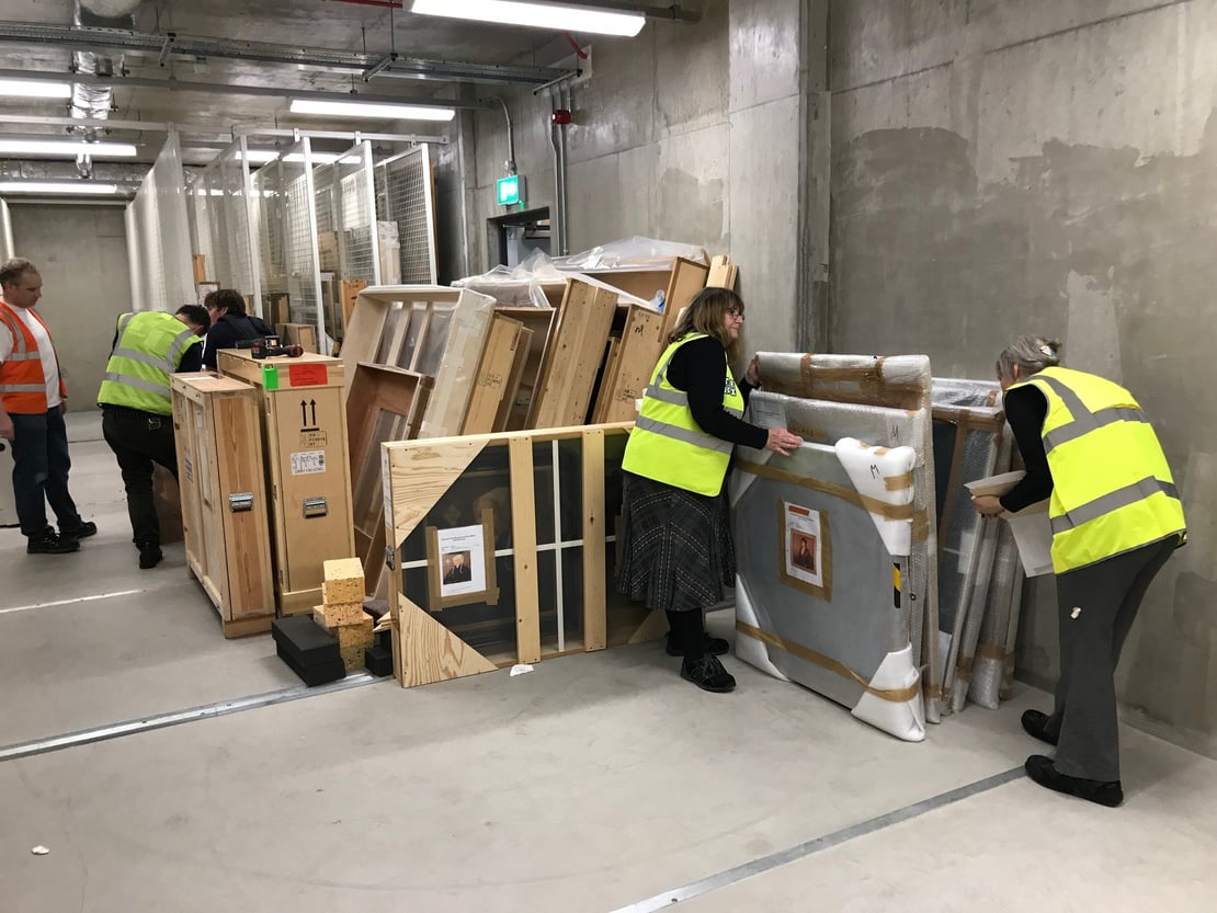 People uncrating large paintings in a store