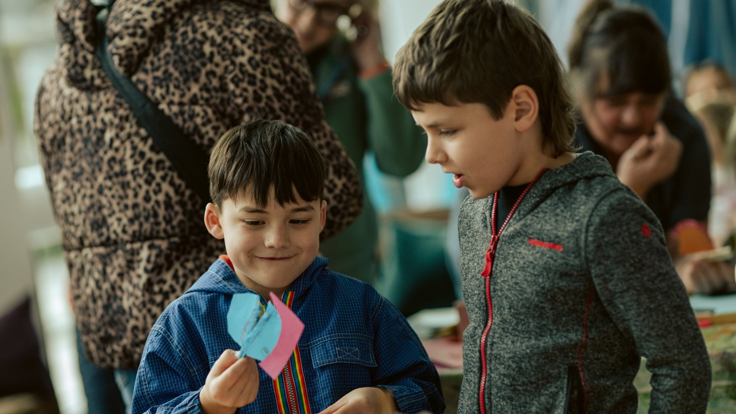 Two boys laugh at the peg people they've made at The Box Plymouth