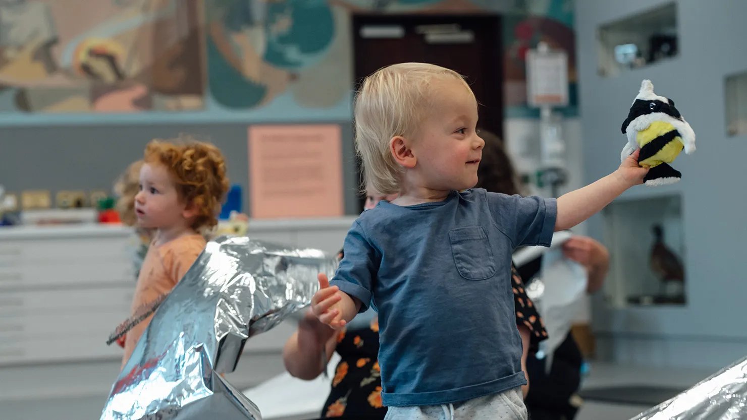 A young boy holding a bee toy in a sensory workshop for toddlers and preschoolers