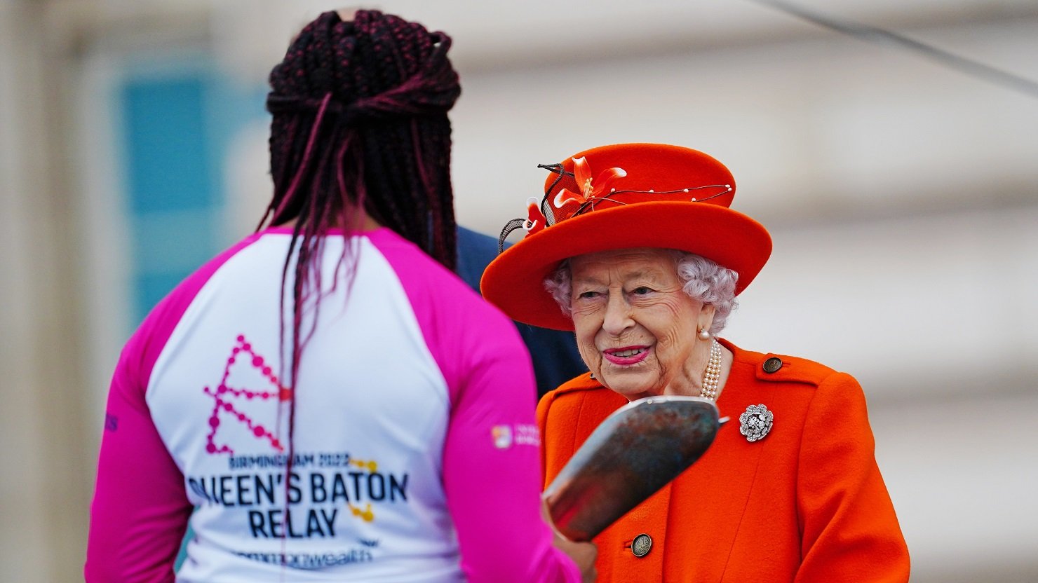 A girl receiving the Baton from the Queen