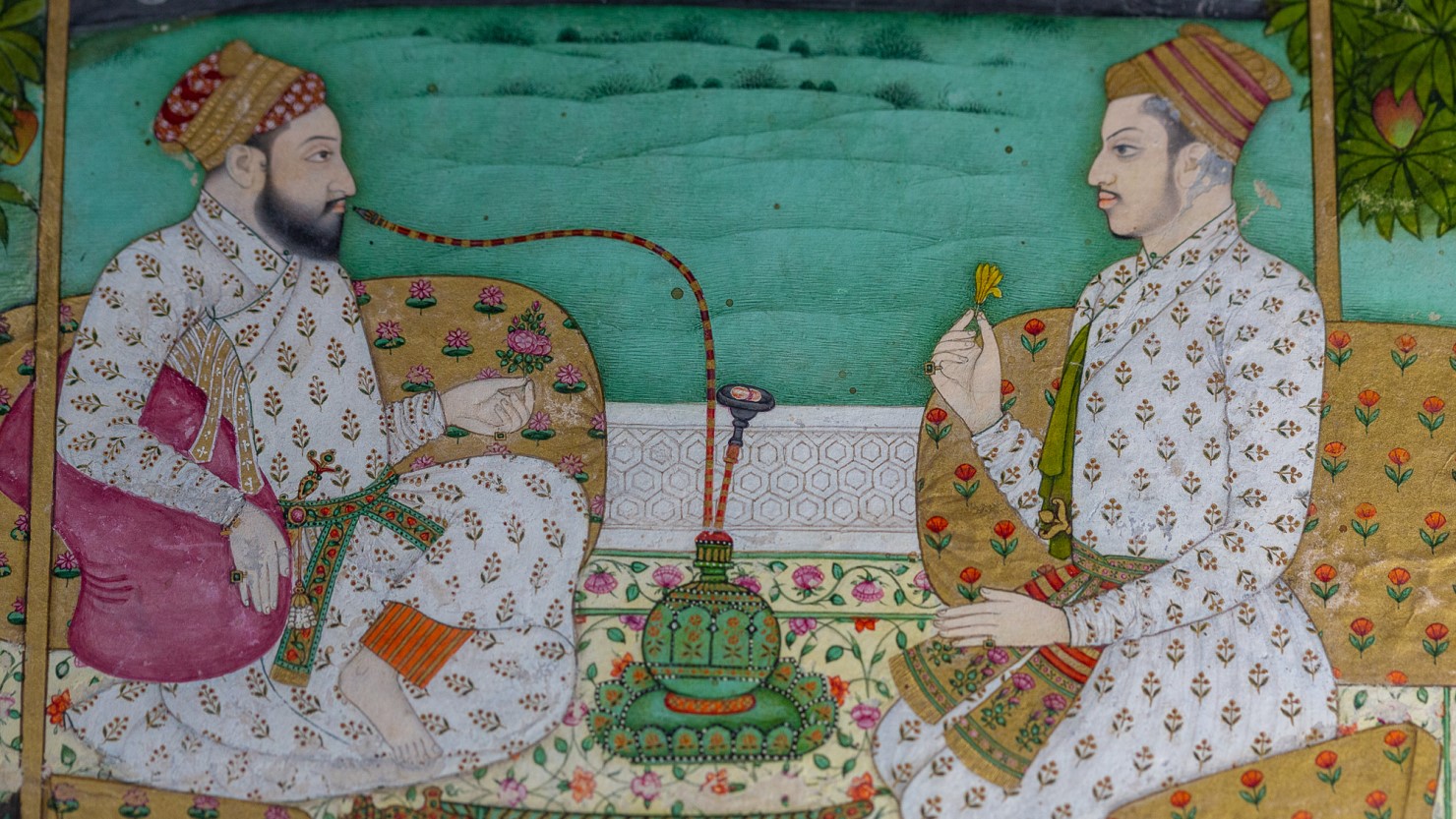 Detail from a painting showing two men sat facing each other on the floor.
