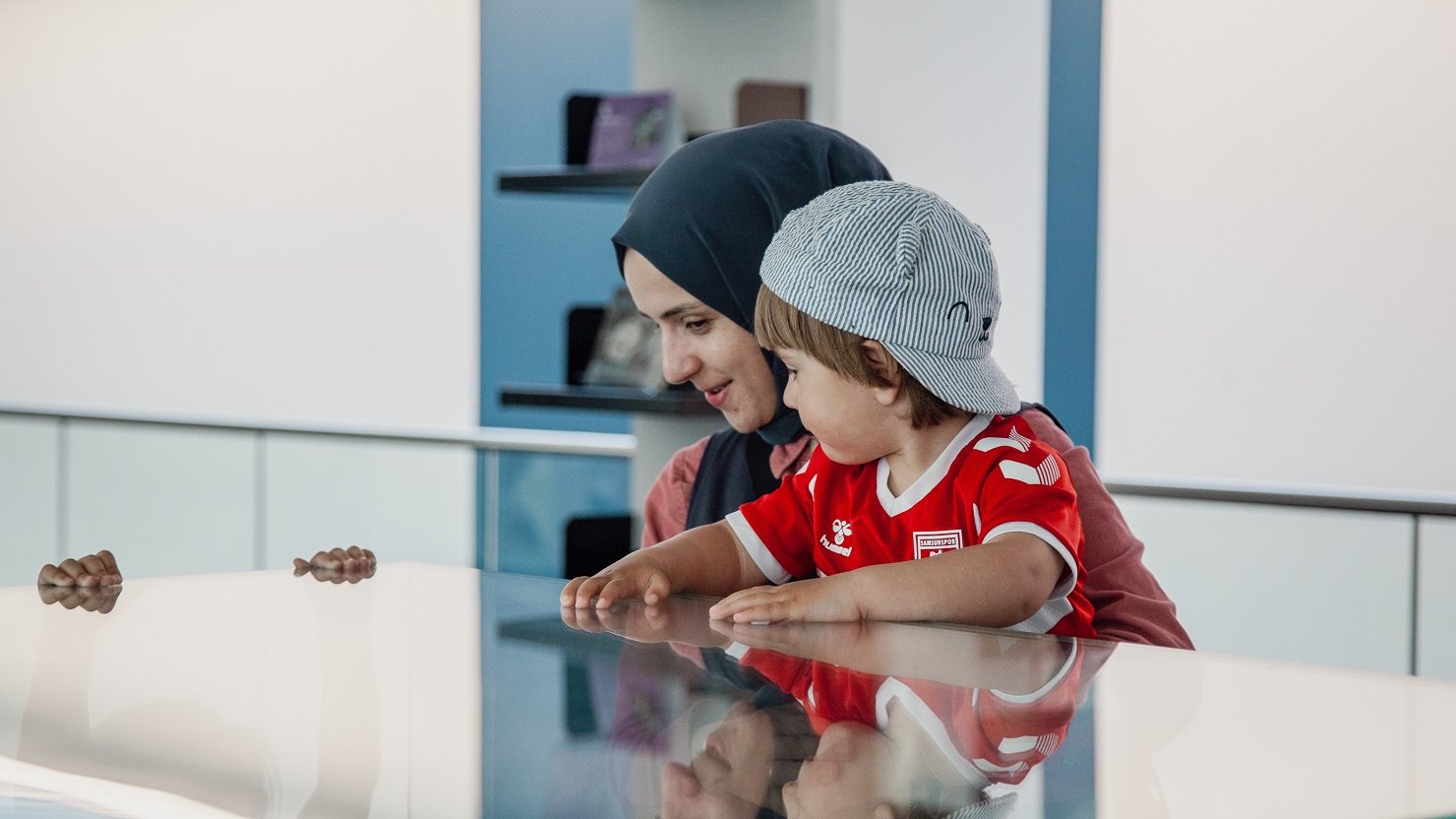 A mum and her young child look at a display case together