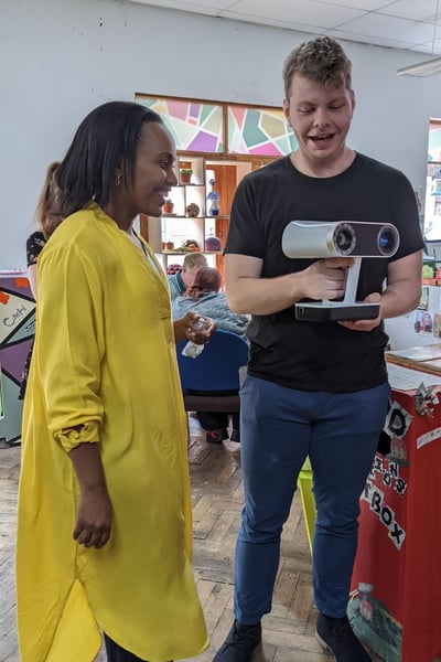 A man demonstrating augmented reality equipment to a woman