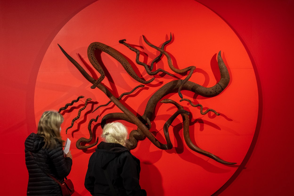 Two visitors look at the Songlines exhibition at The Box