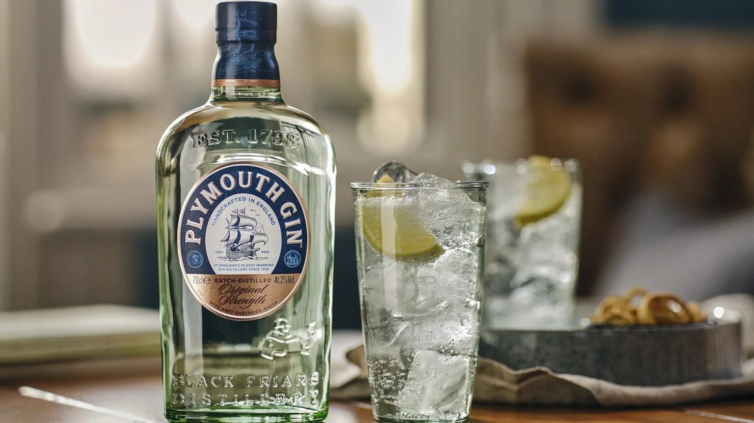 Plymouth Gin bottle and two glasses of gin and tonic