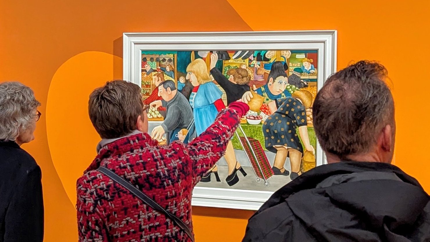 Visitors looking at a Beryl Cook painting on display at The Box Plymouth