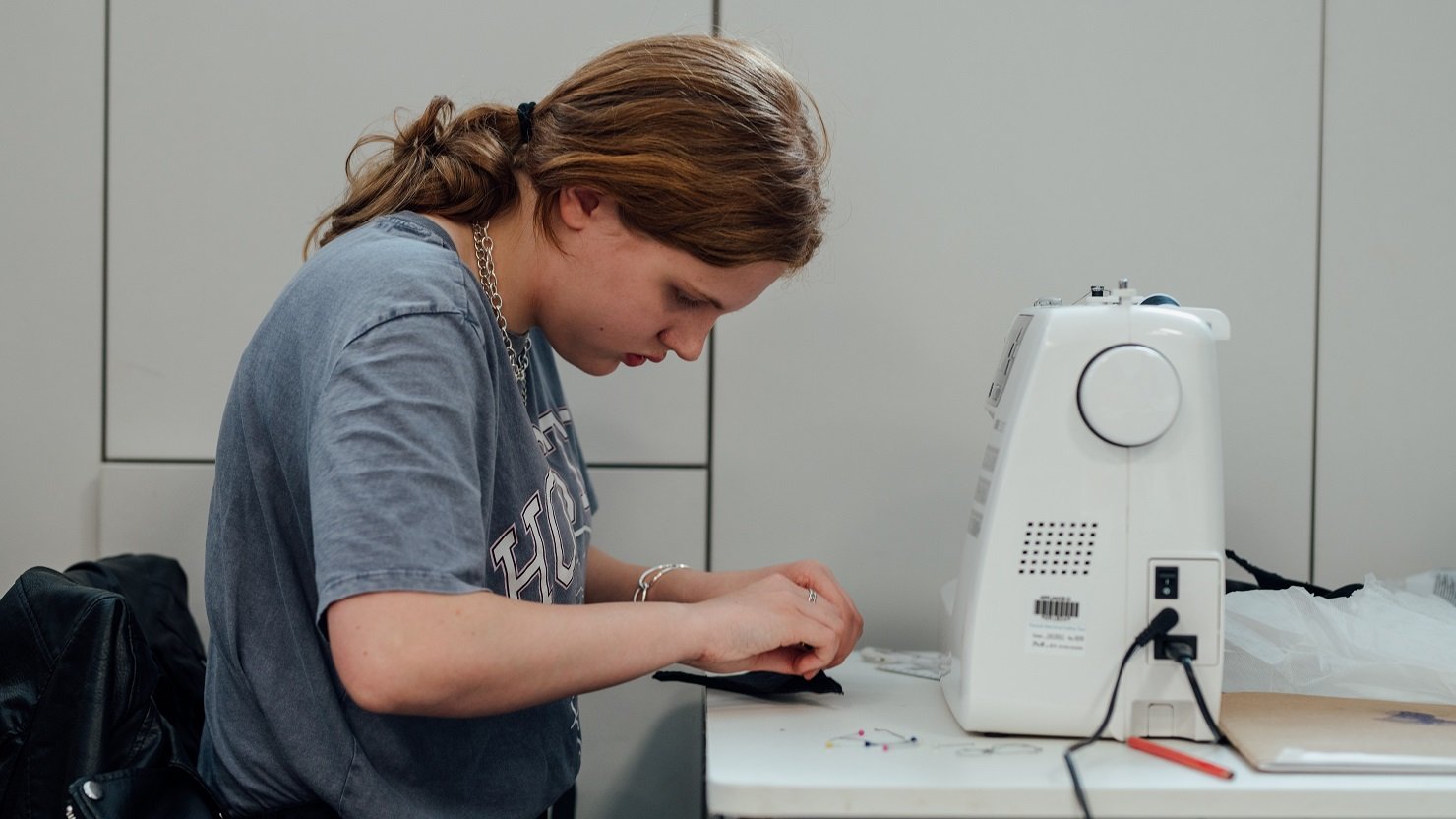 Male student using a sewing machine