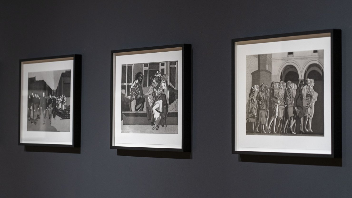 Photograph showing three black and white etchings by Quinlan and Hastings hanging in a gallery