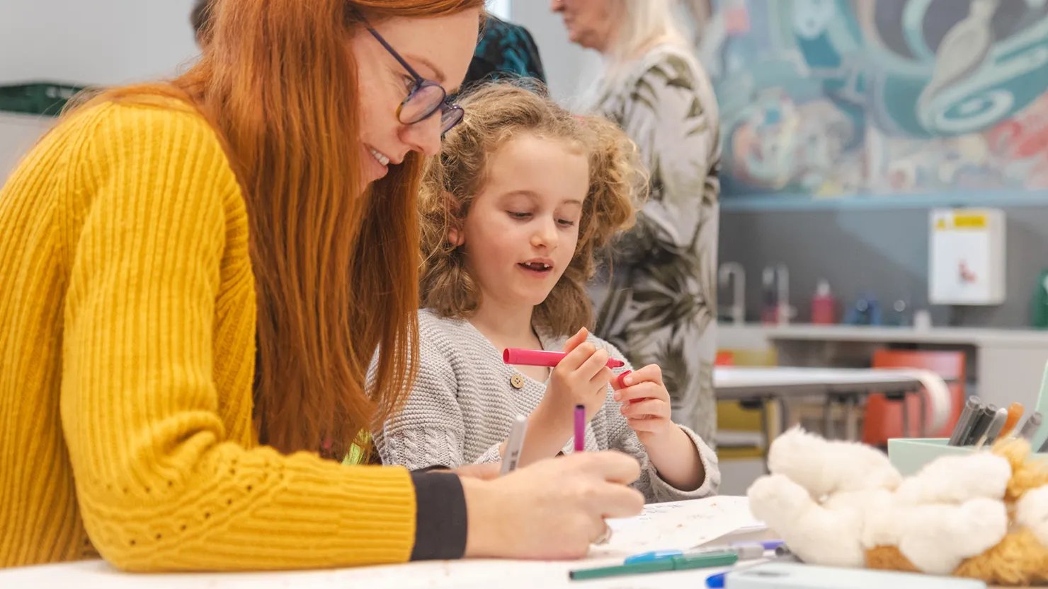 Photograph showing a mother and daughter in a writing workshop
