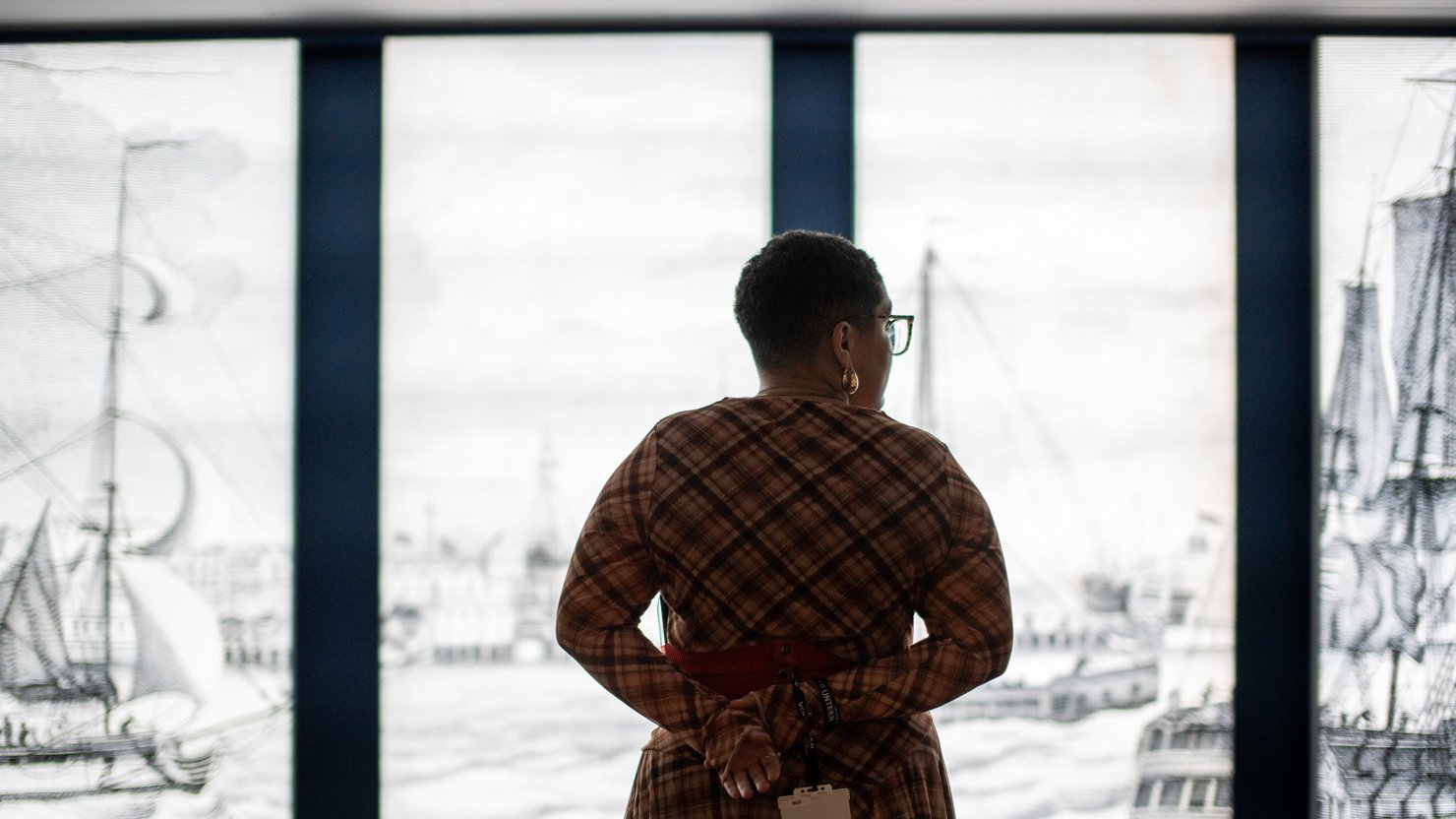 A visitor looking at the 'Journeys with Mai' exhibition at The Box Plymouth