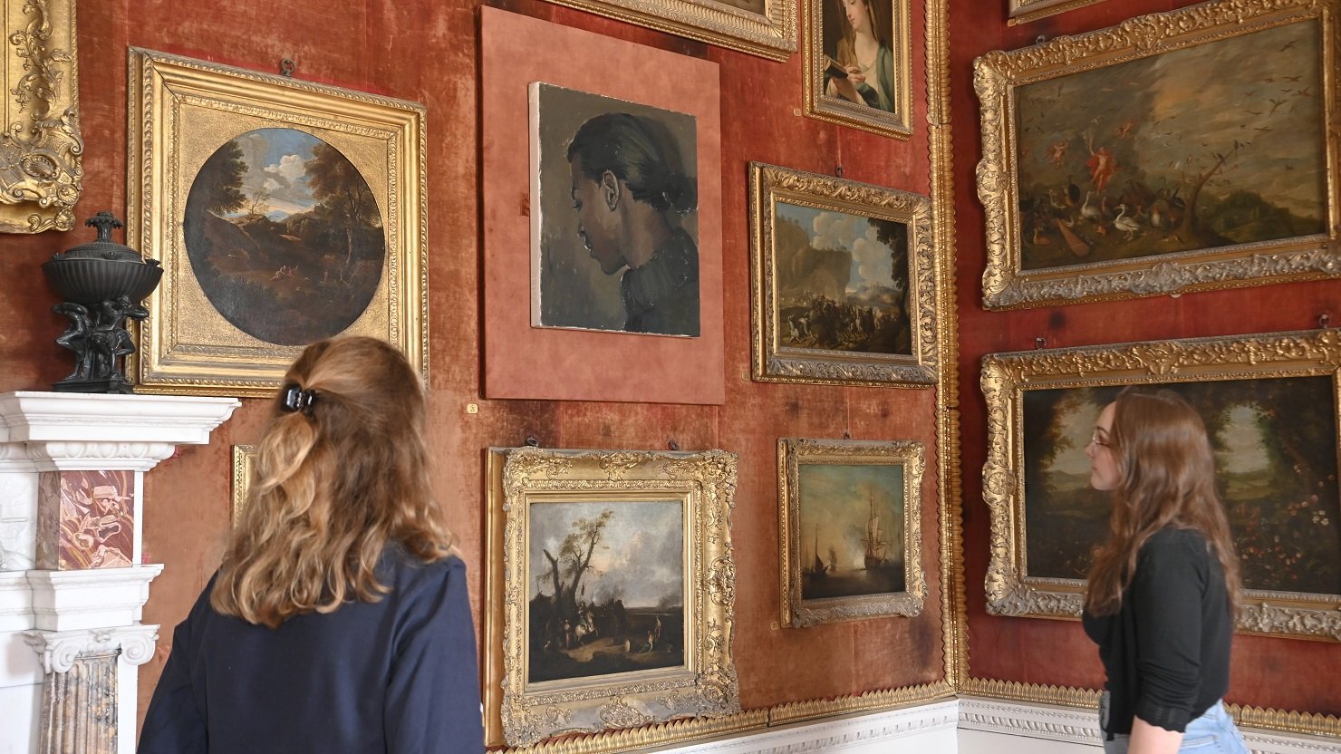 Visitors in the Red Room at Saltram where To Tell Them Where It’s Got To (2013), a small portrait by artist Lynette Yiadom-Boakye is now on display. Credit National Trust Images Jay Williams