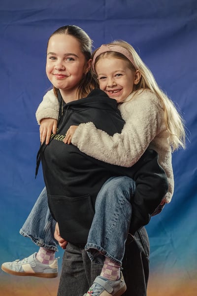 A girl giving a younger girl a piggyback