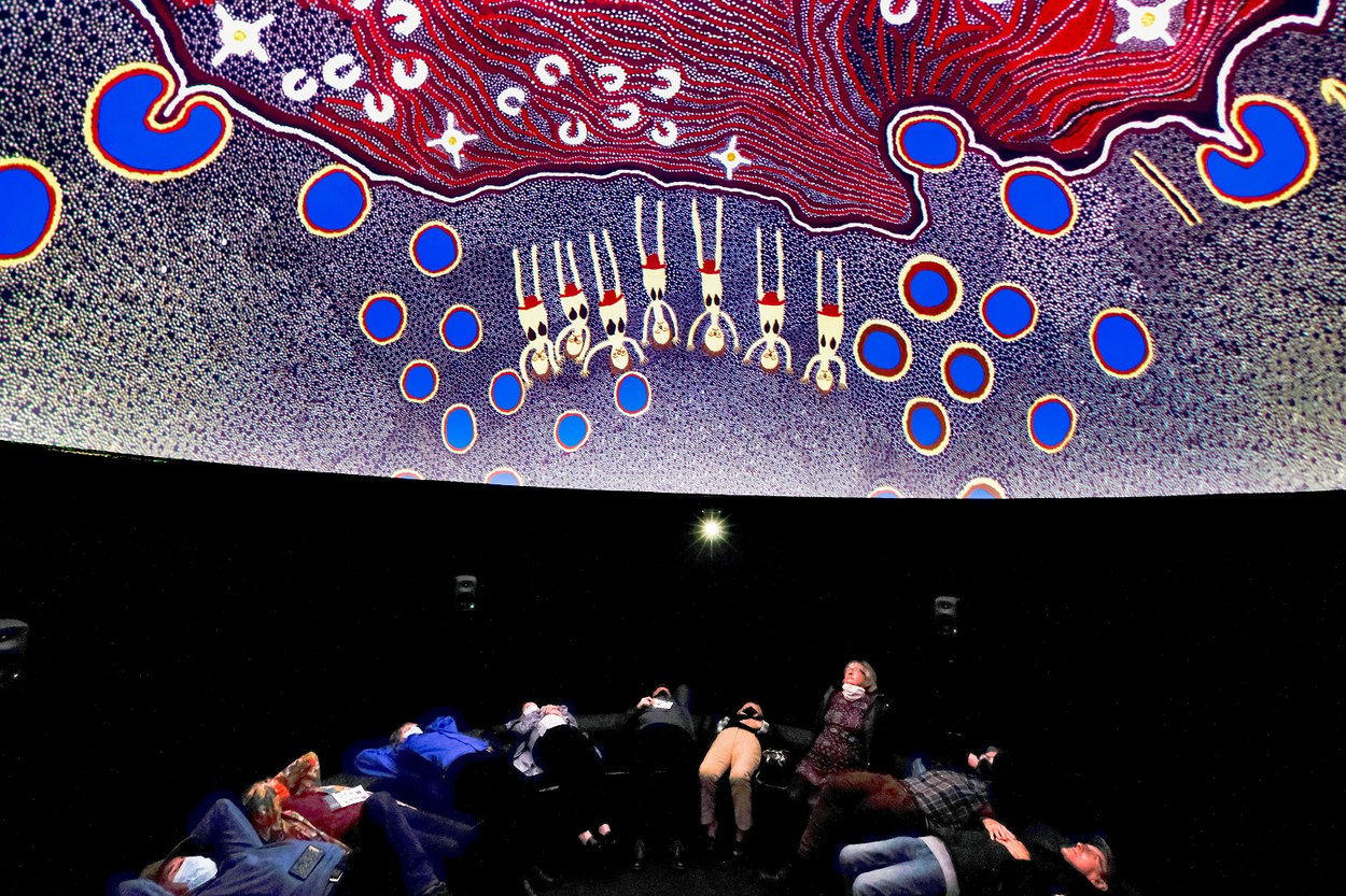 Visitors watching a projection in the immersive 'Songlines' dome