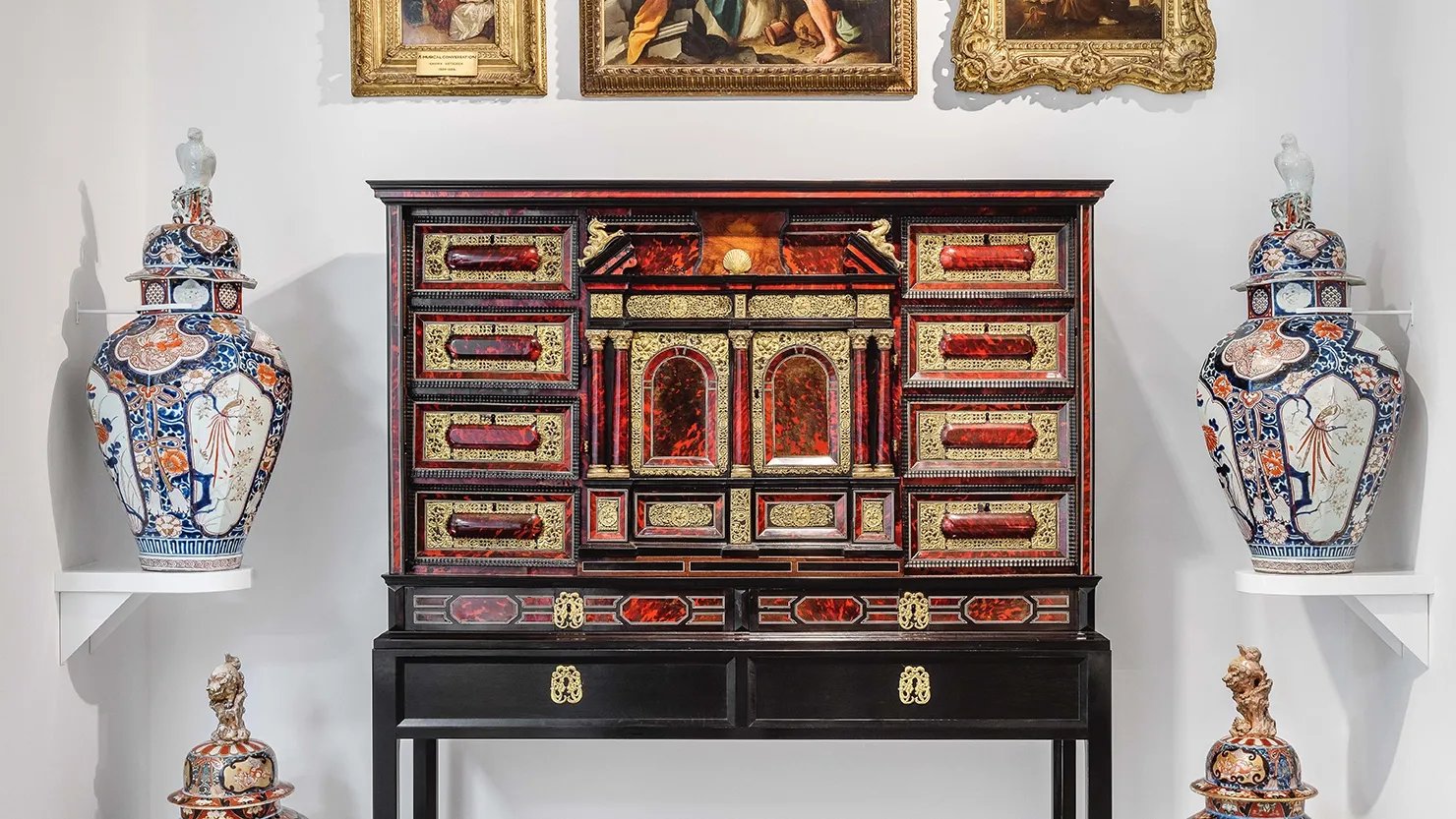 Photograph of ornate collectors' cabinet and large ceramics on display