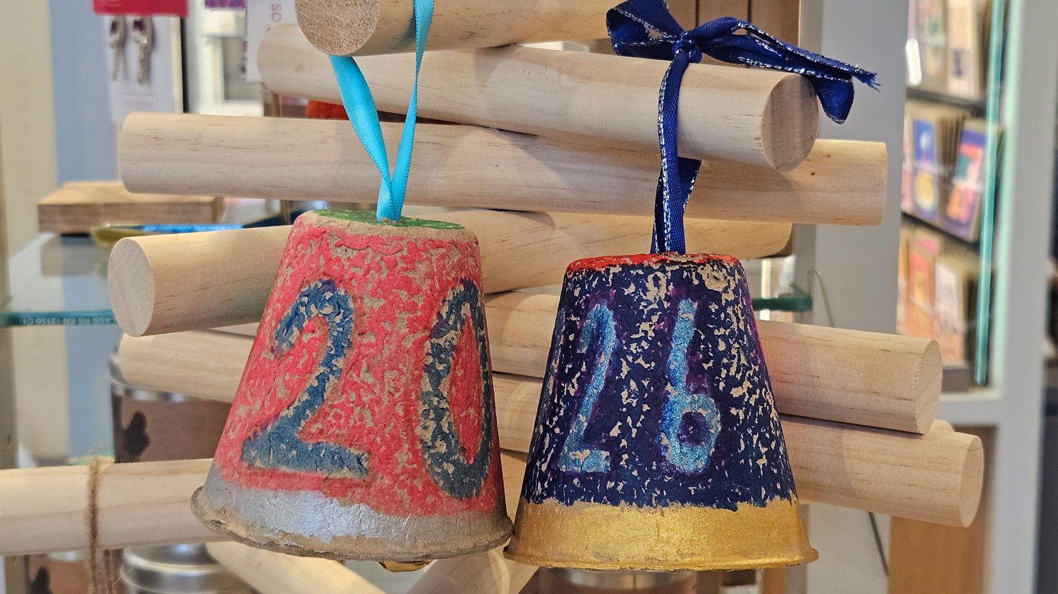 Two bells made from paper pots with 2026 on them