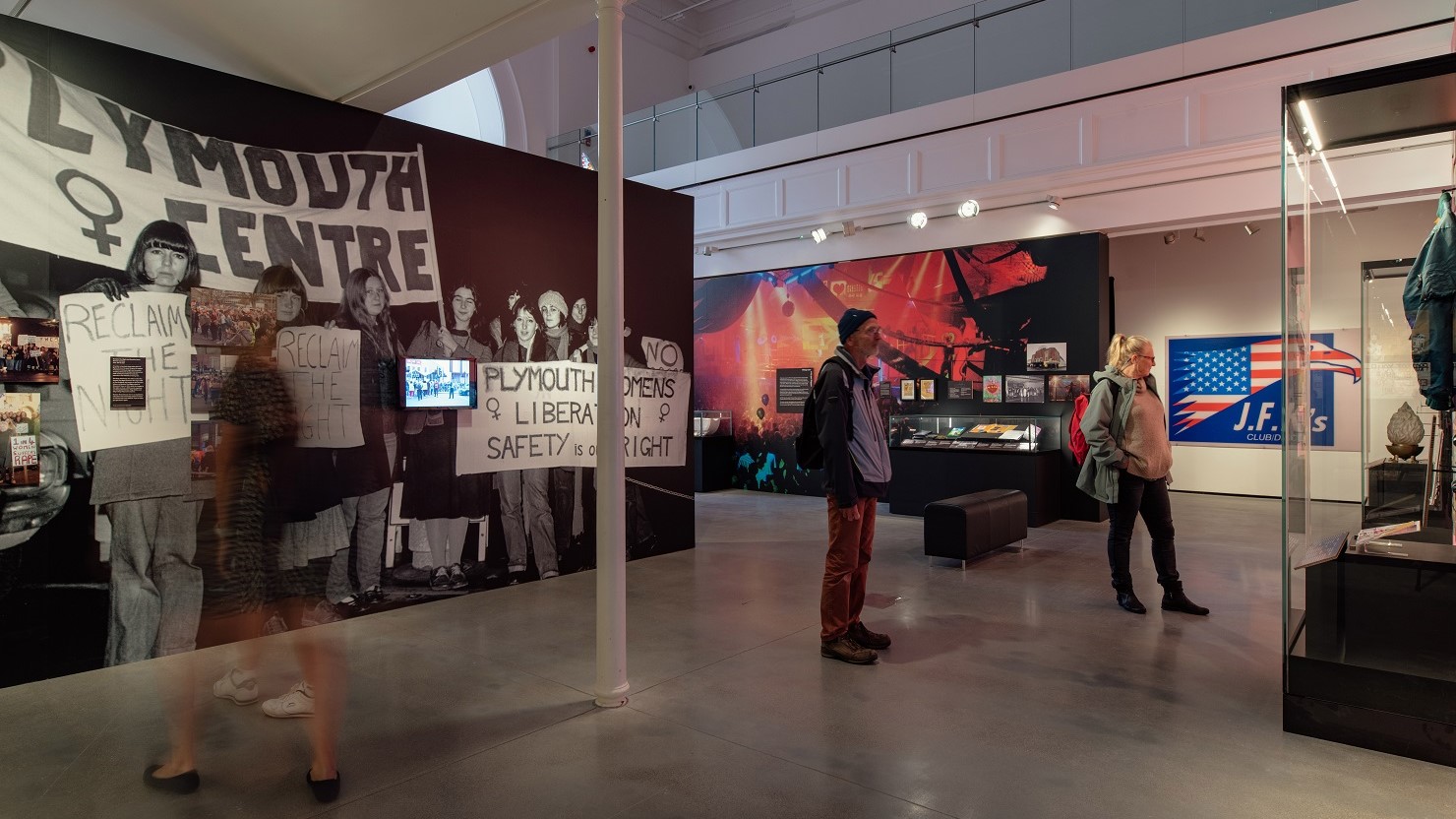 Visitors looking at the 'because the night belongs to us' exhibition