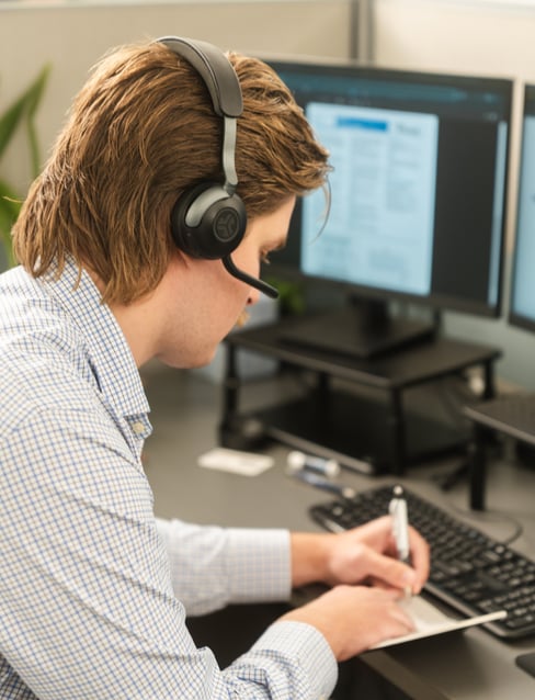 Picture of a KaTom call center employee writing in notepad