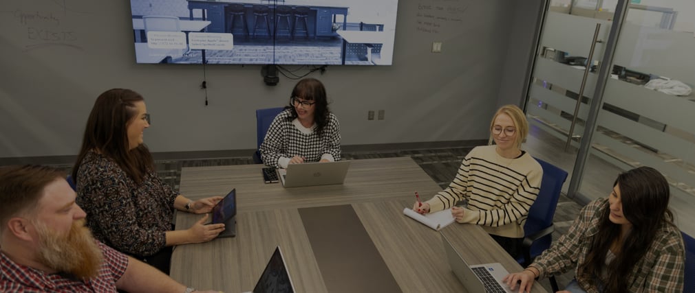 Picture of KaTom employees sitting at table in meeting