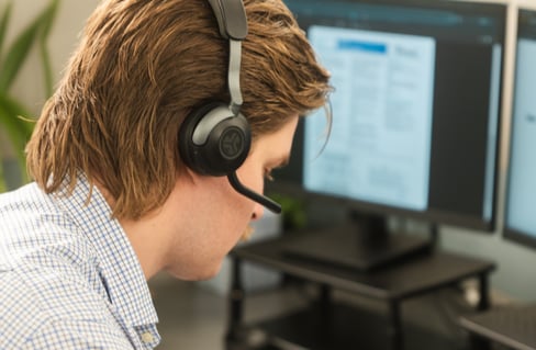Picture of a KaTom call center employee writing in notepad