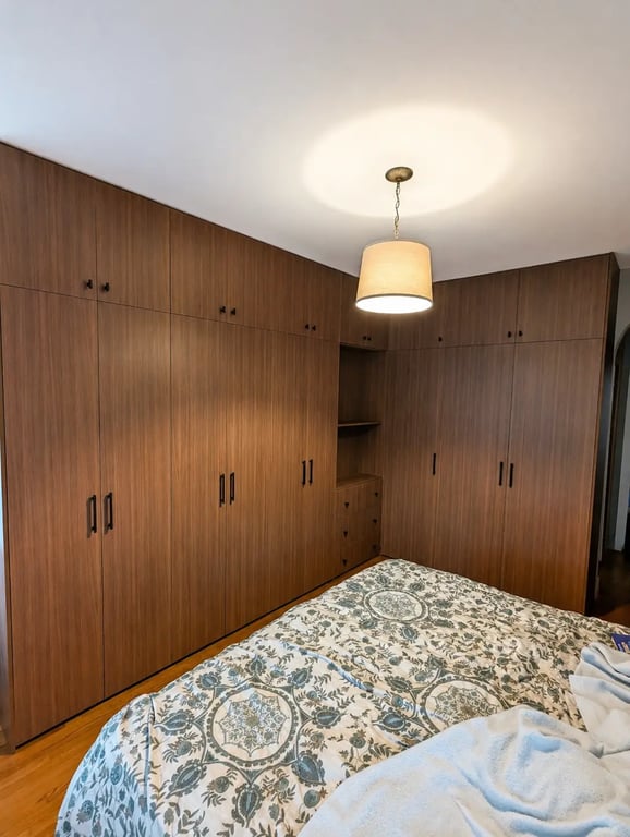 Garde-robe intégrée haut de gamme du sol au plafond avec finitions en bois riche, projet réalisé à Westmount, Montréal.